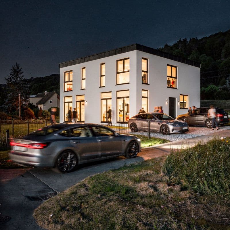 Nachtansicht einer modernen Villa mit warm erleuchteten Innenräumen
